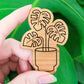 Handcrafted magnet featuring a monstera deliciosa plant engraved in cherry wood held in hand for size perspective.