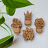 Four handcrafted magnets featuring different houseplant designs engraved in cherry wood.