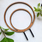 Round circle double hoop wooden indoor plant trellis with rubber dipped stakes on white background.